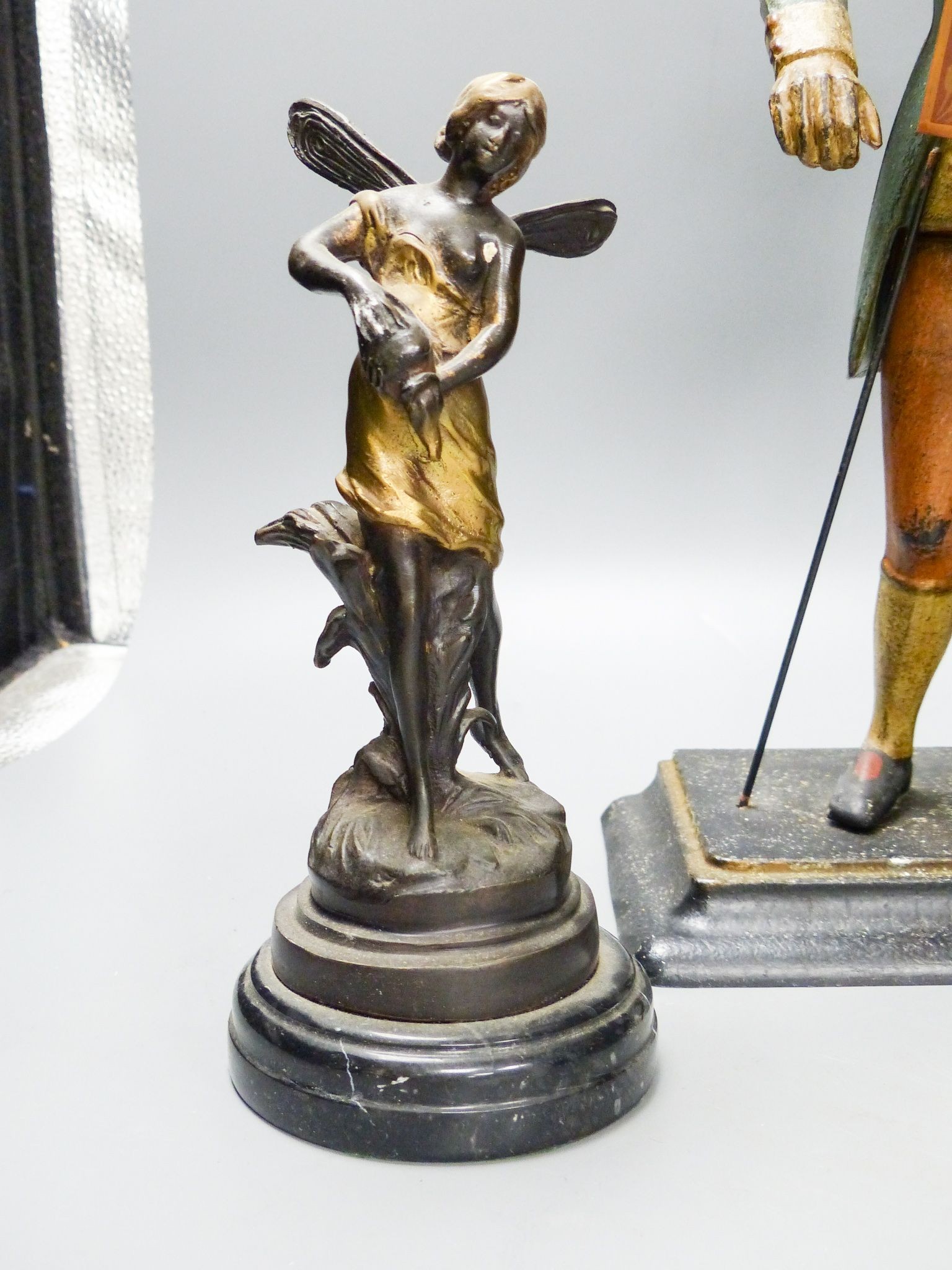 A painted cast iron figure all mantle timepiece and a pair of bronze figures of fairies, tallest 40 cm high